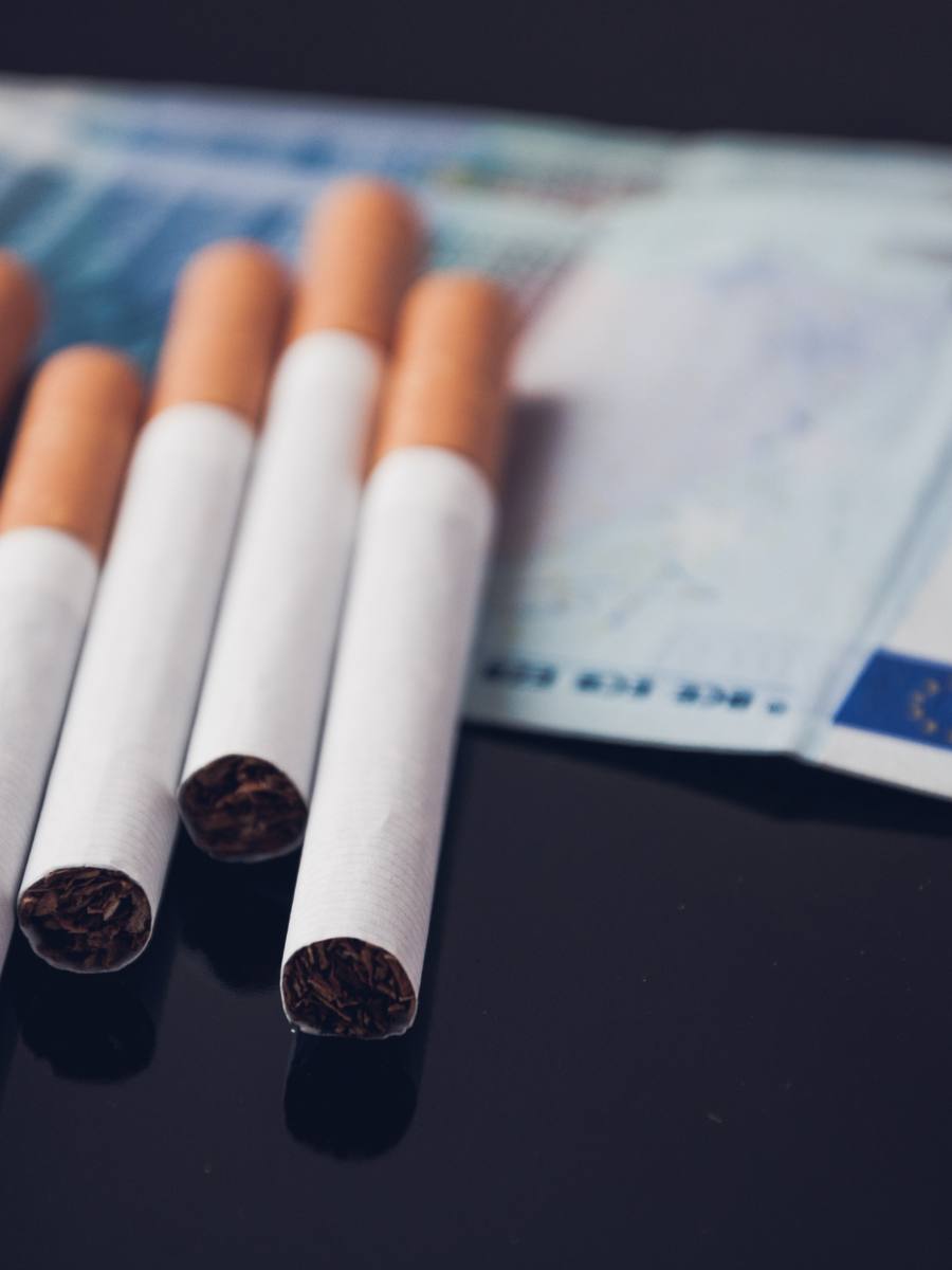 Taxa pe tutun va fi majorată semnificativ. Foto: țigări și o bancnotă euro
