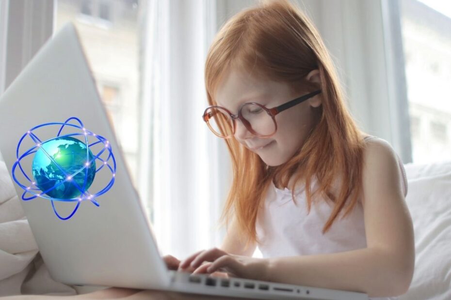 Fetiță roșcată navighează pe internet de pe un laptop