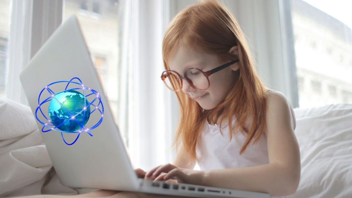 Fetiță roșcată navighează pe internet de pe un laptop