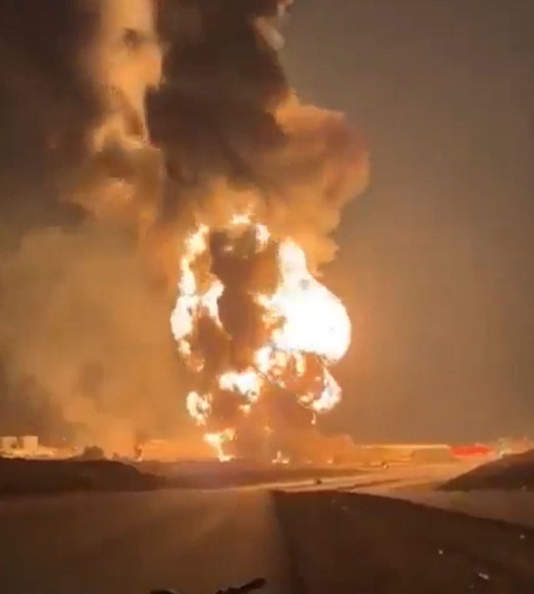 Flăcări de proporții și un nor imens de fum negru se ridică deasupra unei instalații industriale cuprinse de incendiu.