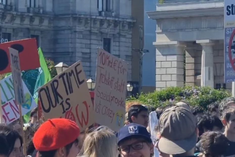 Manifestanți la un protest pentru protecția climei în Viena, Austria, cu pancarte și mesaje împotriva schimbărilor climatice.