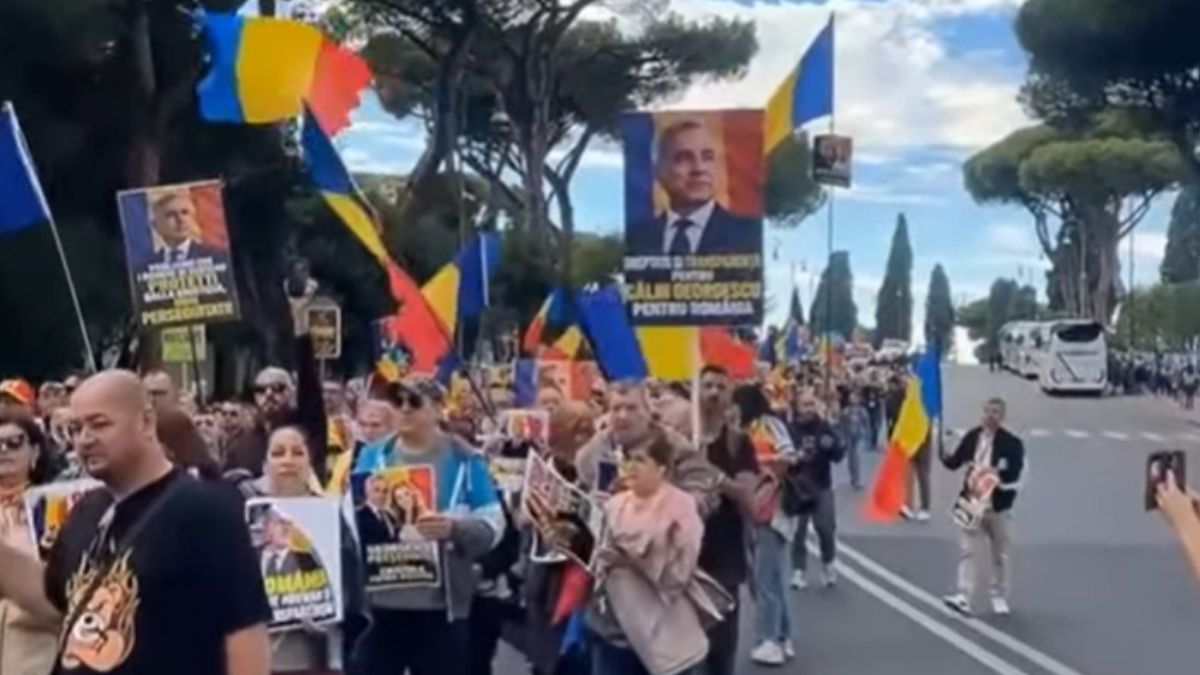Manifestanți români cu steaguri tricolore și afișe cu Călin Georgescu la marșul din Roma